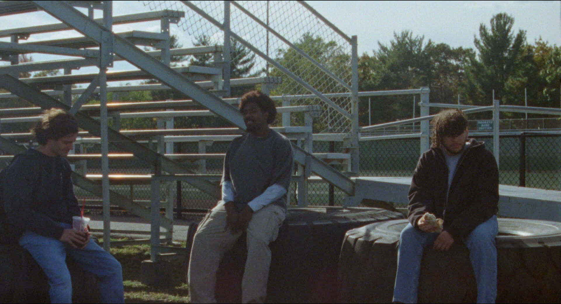Tom and his friends sit behind the bleachers after school.